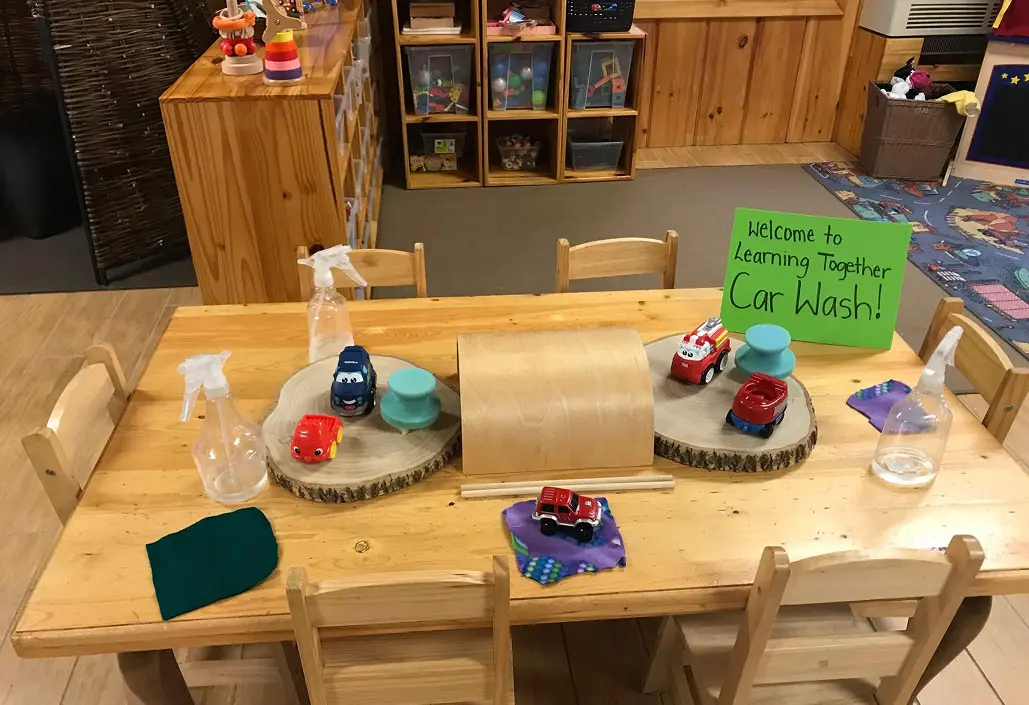Learning Together Childcare car wash activity with toy vehicles and cleaning supplies