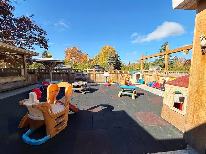 Learning Together Childcare fenced outdoor playground with playhouses and activity equipment