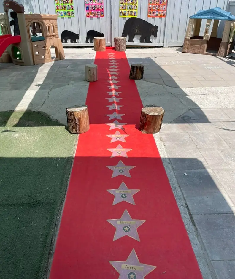 Learning Together Childcare outdoor play area with a red star walkway and wooden stepping stools