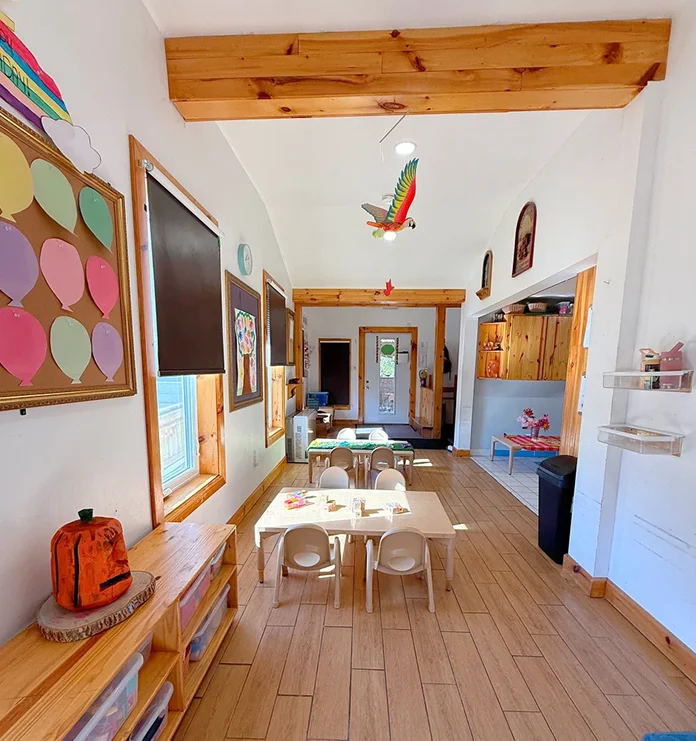 Learning Together Childcare classroom with child-sized tables and natural wood finishes